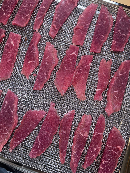 Hand-cut Australian beef strips laid on a dehydrator tray at Pooches Pantry