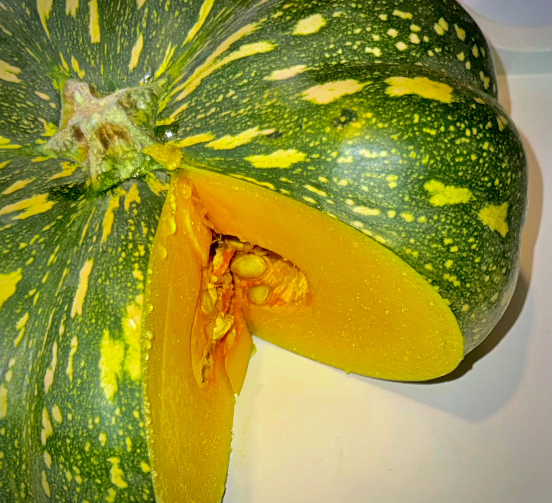 A Jap pumpkin cut open to show its bright orange flesh and seeds