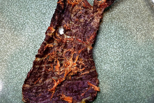 Slow-dehydrated Pooches Pantry beef and carrot strip on a green plate