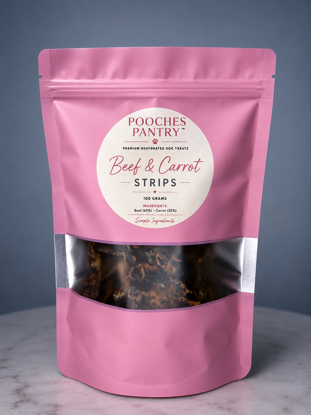 Beef & Carrot dog treats in a pink Pooches Pantry bag on a marble bench